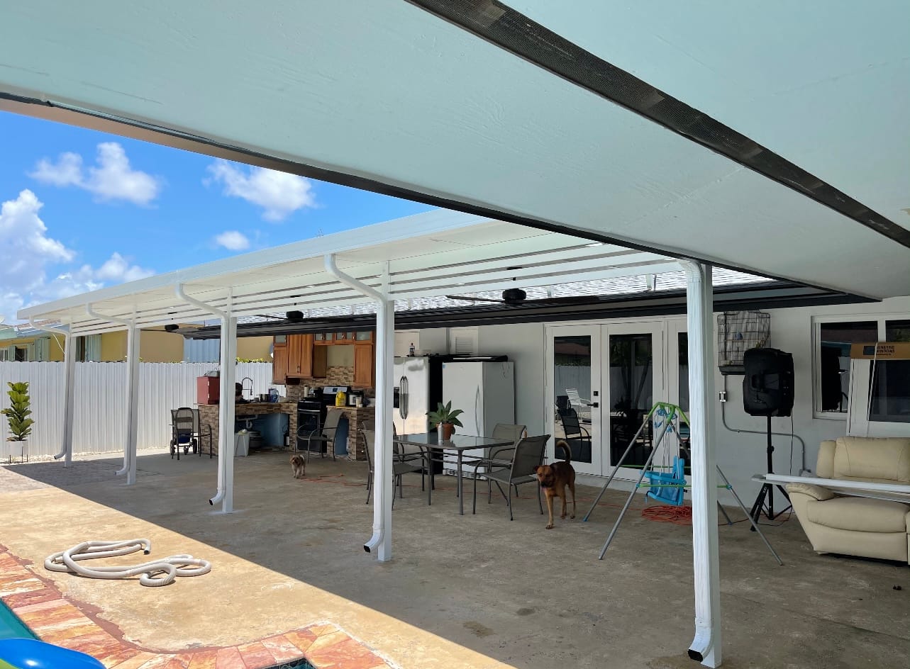 Large white aluminum patio cover shading a backyard patio and outdoor kitchen in South Florida